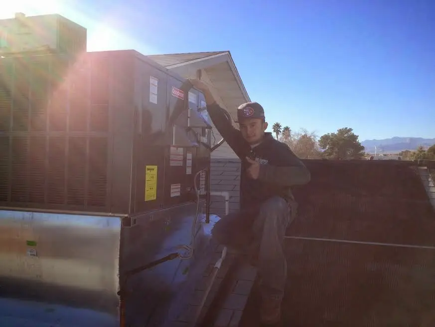 HVAC technician performing Boiler Repair on a rooftop unit in Erwin
